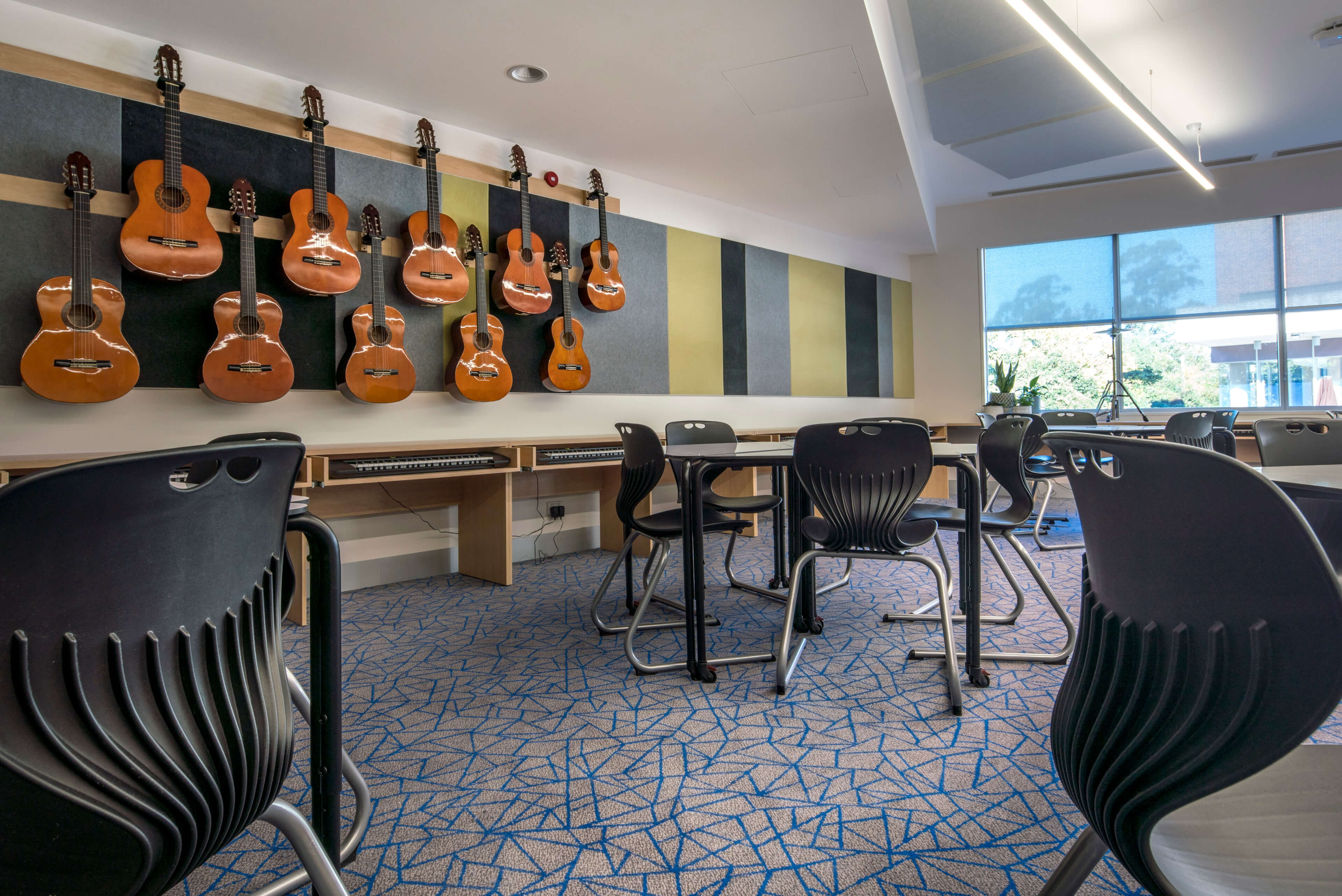 16 guitars on the wall of a specialised music classrooms at knox performing arts centre taylor construction education