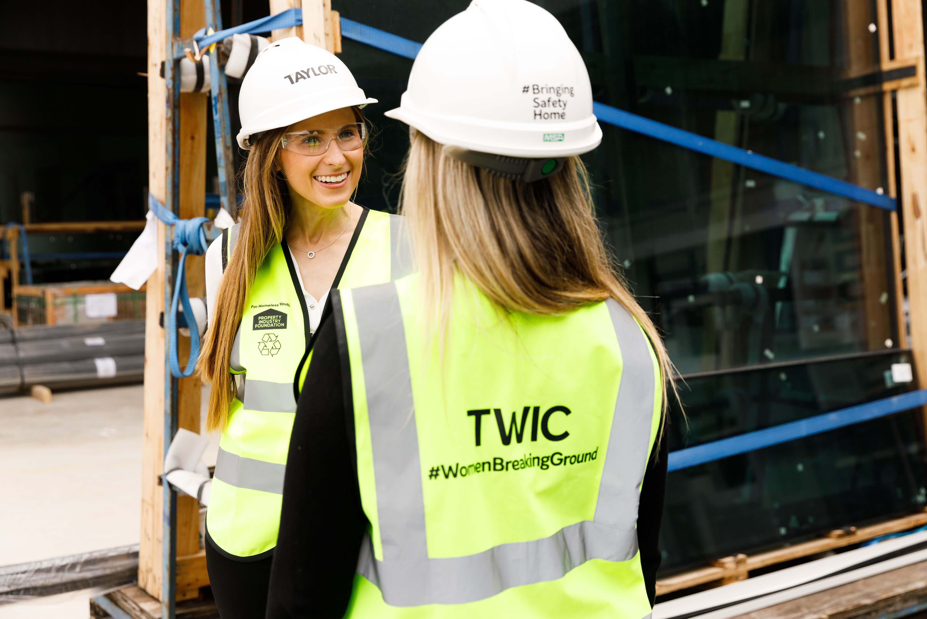 4 two female employees discussing project onsite taylor construction photography twic women breaking ground